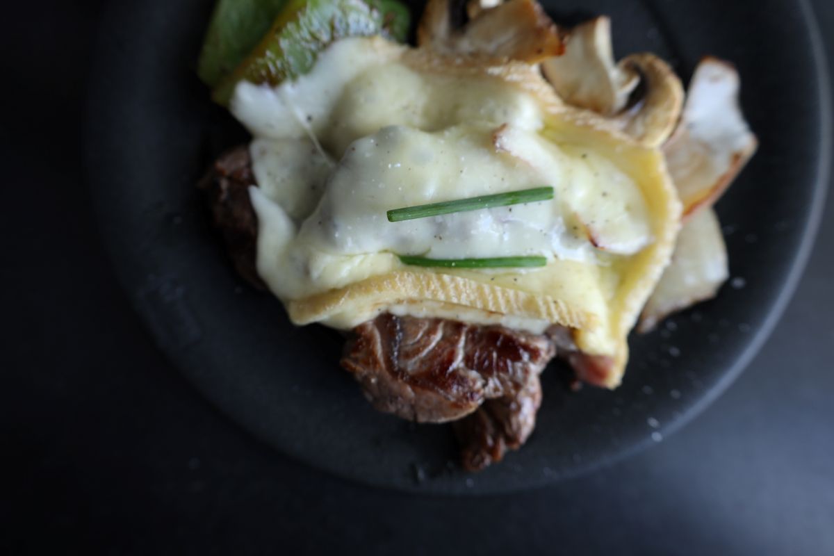 raclette cheese on steak and veggies