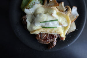 raclette cheese on steak and veggies