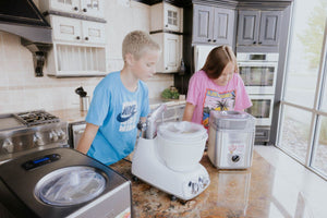 Two people using ice cream machines to churn basic vanilla ice cream base. 