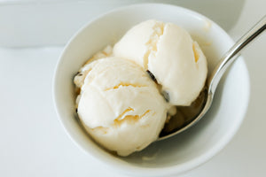 no-churn vanilla ice cream scooped into a small bowl with a spoon. 