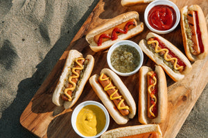 Perfectly grilled hot dog in a toasted bun topped with mustard, ketchup, and relish