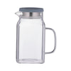 Clear glass pitcher with a gray lid on a white background