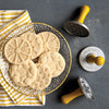 Decorative cookies on a plate with cookie stamps on a gray surface