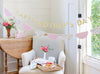 Decorated room with 'Happy Mother's Day' banner, flowers, and a tray of food on a chair.