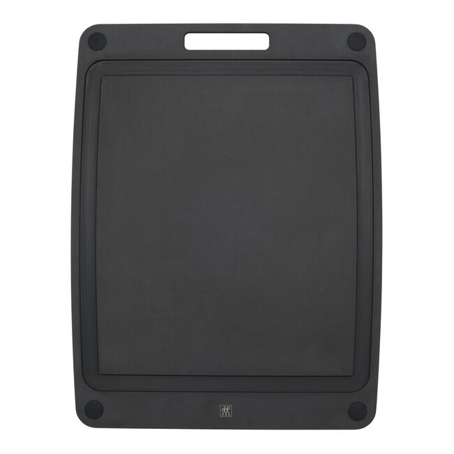 Black rectangular cutting board with deep juice groove on a white background