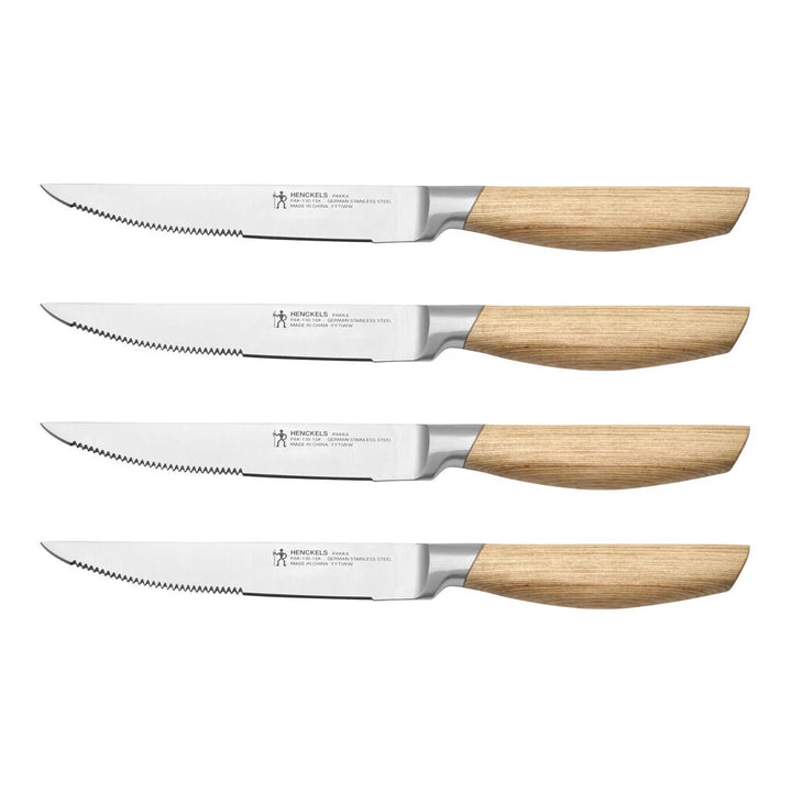 Set of four steak knives with wooden handles on a white background