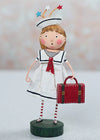 Decorative figurine of a girl in a sailor outfit with a red suitcase on a white background