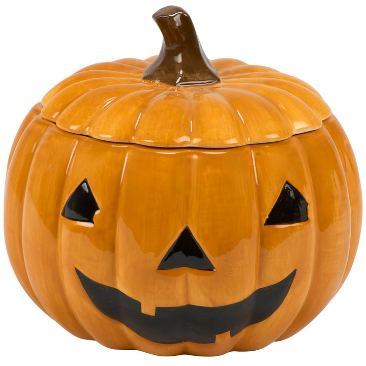 A glossy ceramic pumpkin-shaped container with a lid, featuring a black carved jack-o'-lantern face.