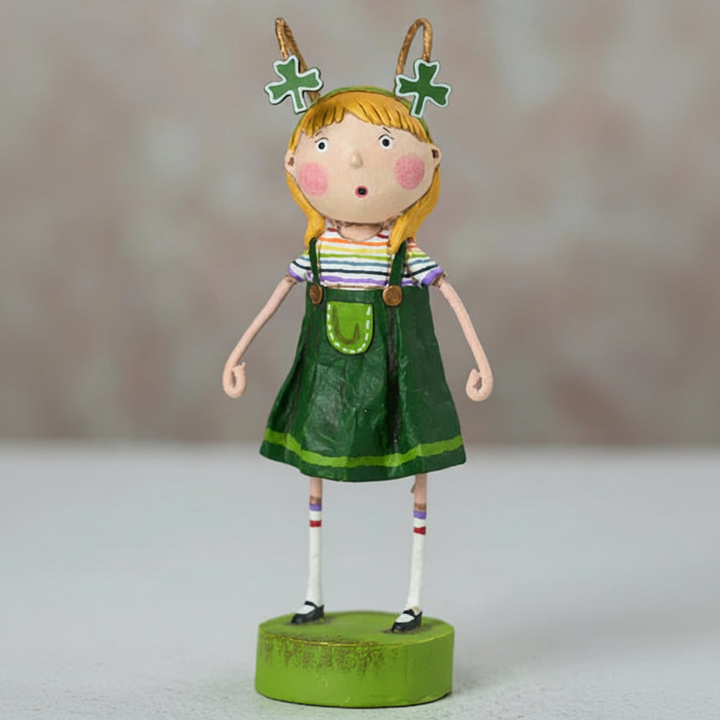 Decorative figurine of a girl in a green dress with shamrock decorations on a neutral background
