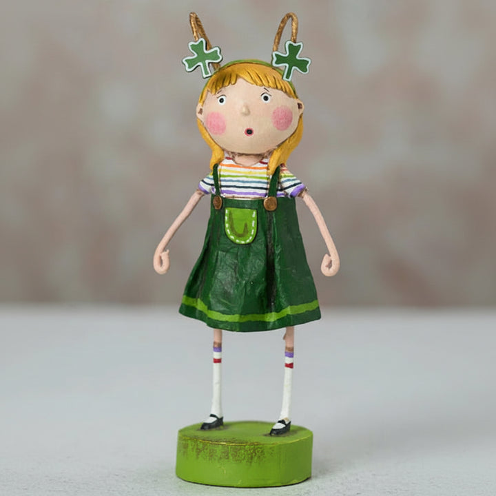 Decorative figurine of a girl in a green dress with shamrock decorations on a neutral background