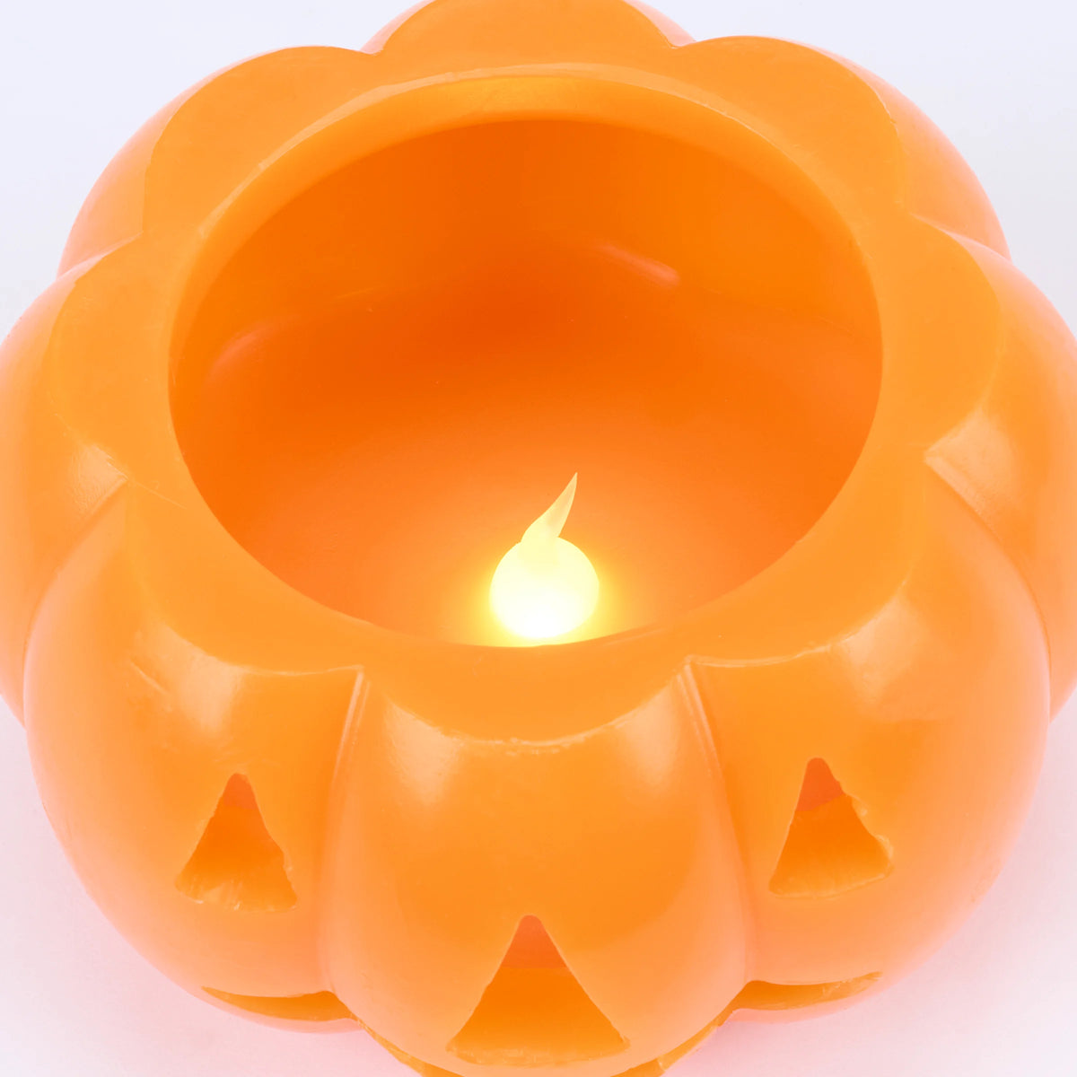An orange plastic jack-o'-lantern-shaped candle holder with a glowing LED flame effect inside, shown on a clean white background.