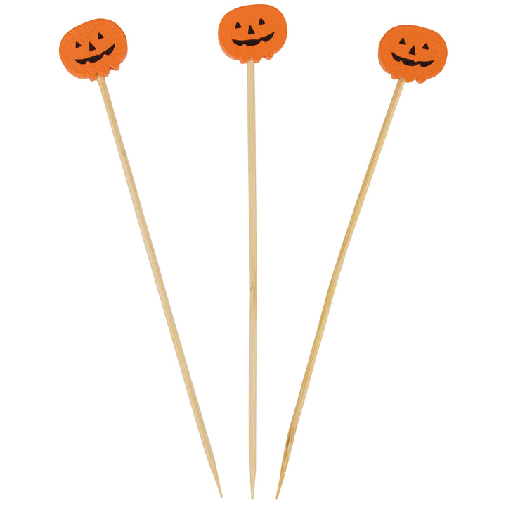Three Halloween-themed tooth picks with orange jack-o'-lantern tops on wooden sticks, shown against a plain white background.