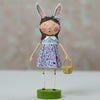 Doll with rabbit ears holding a basket on a neutral background