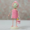 Figurine of a girl in a polka dot towel with a pink towel on her head, holding a small bucket with a duck toy.