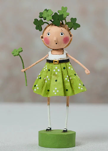 Decorative figurine of a girl in a green dress with shamrock accessories on a neutral background