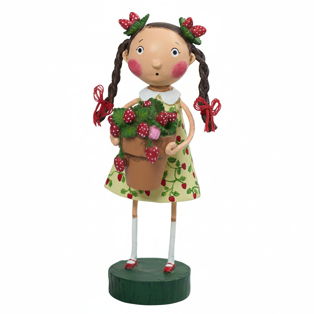 Decorative figurine of a girl holding a pot of strawberries, wearing a green dress adorned with strawberries; her hair is styled in braids with bows made of strawberries; on a white background.