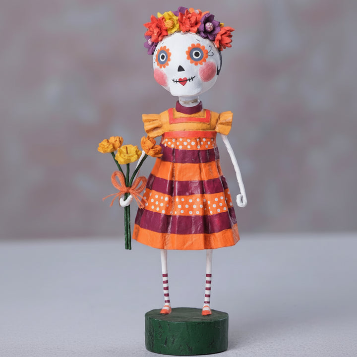 Decorative figure with a colorful dress and floral headpiece on a white background