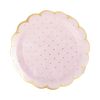 Pink paper plate with gold polka dots and a scalloped edge on a white background