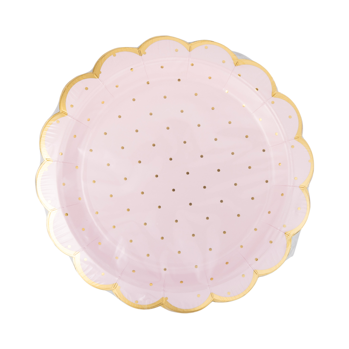 Pink paper plate with gold polka dots and a scalloped edge on a white background