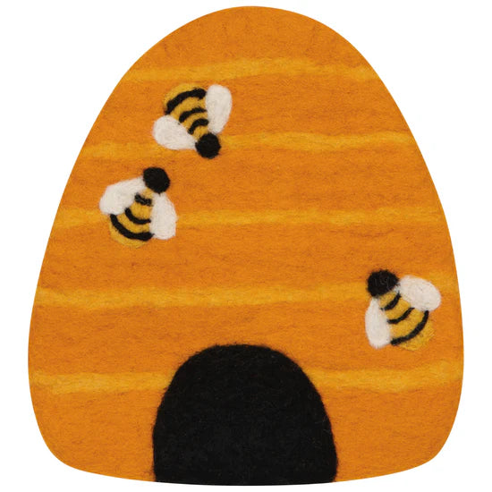 Orange beehive shaped trivet with black and white bee designs on a white background