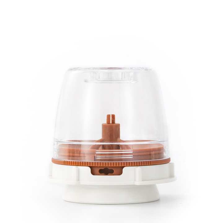 Clear peppercorn grinder with brown base and lid on a white background