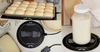 Round Bakehouse Dough Mat with bread rolls, jar of dough, and rolling pin on a kitchen counter.