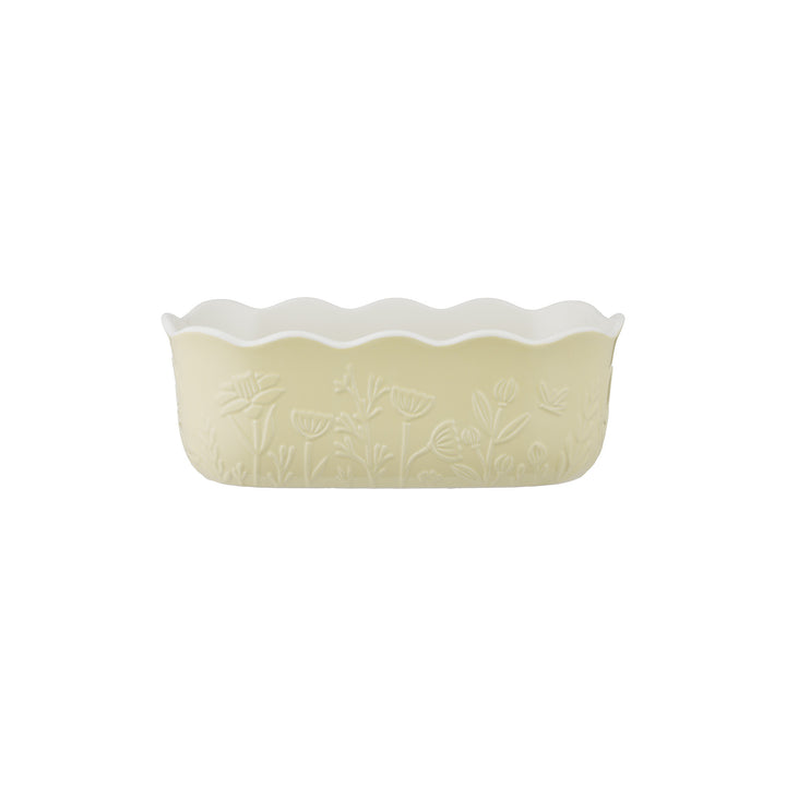 Yellow ceramic pie dish with floral pattern on a white background
