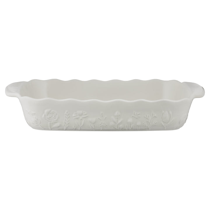 White ceramic baking dish with floral patterns on a white background