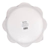 Back side view of scalloped paper plate with a label on a white background