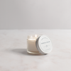 Candle in a glass jar with a white lid on a light gray background