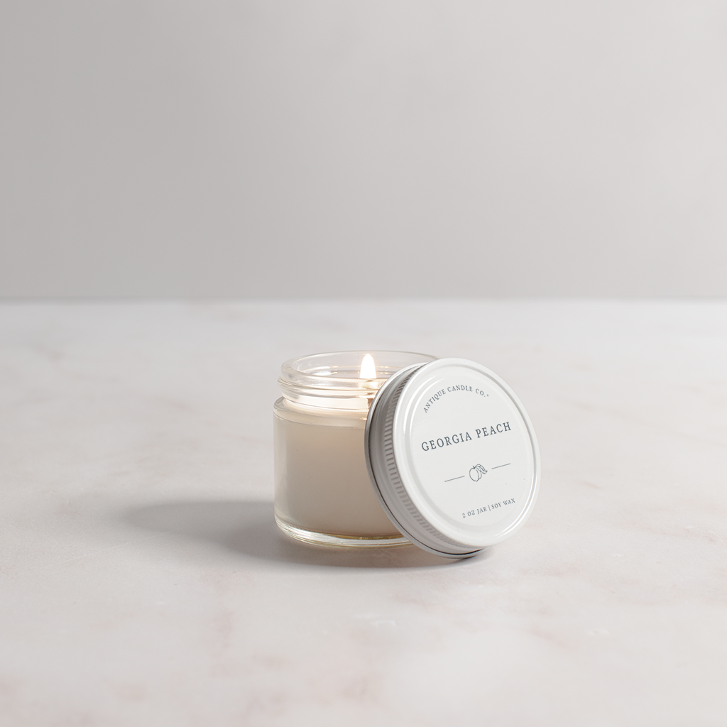 Candle in a glass jar with a white lid on a light gray background
