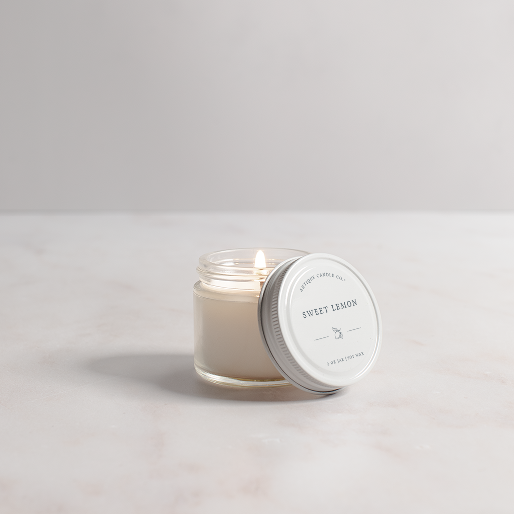 Candle in a glass jar with a white lid on a light gray background