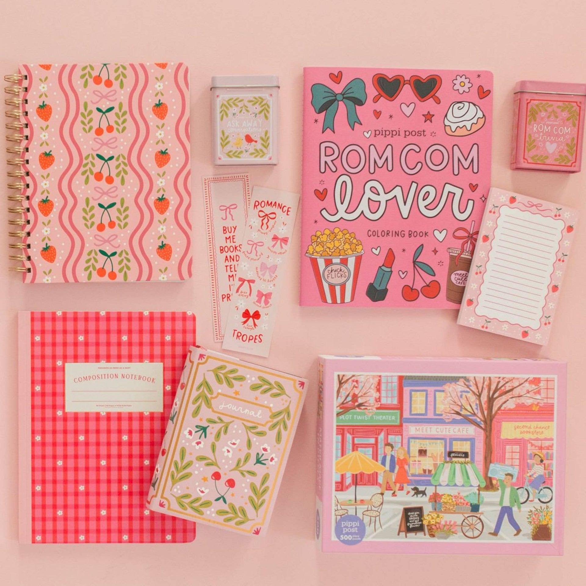 Collection of pink stationery items including notebooks and coloring books on a pink background