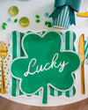 Green shamrock-shaped plate with 'Lucky' text on a festive table setting.