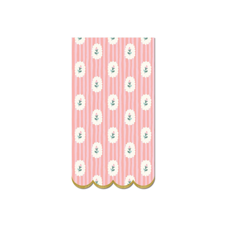 Scallop-edged napkin with white floral pattern on pink striped background