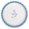 Round white plate with blue floral design and scalloped edge on a white background