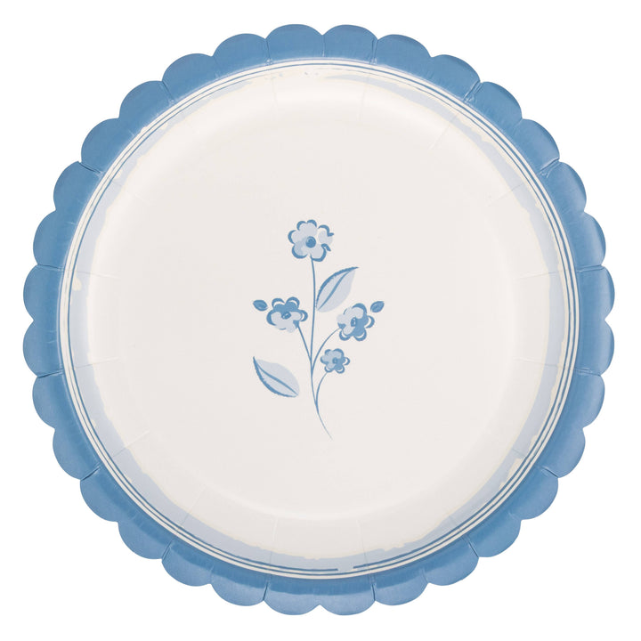 Round white plate with blue floral design and scalloped edge on a white background