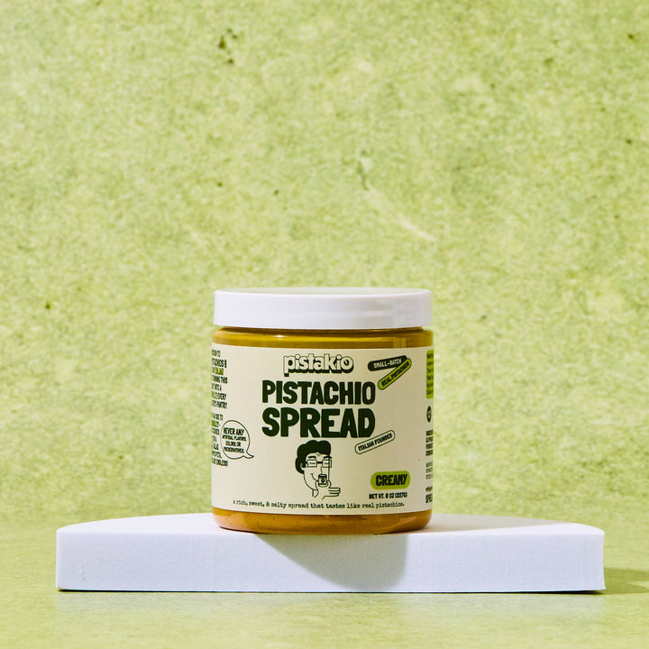 Jar of pistachio spread on a green background