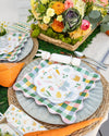 Easter-themed table setting with decorative plates, napkins, and a floral centerpiece.