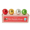 Four hot chocolate bombs in red, gold, silver, and green foil packaging on a white background.