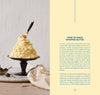 Whipped butter on a small black stand with a knife, on a light wooden surface.