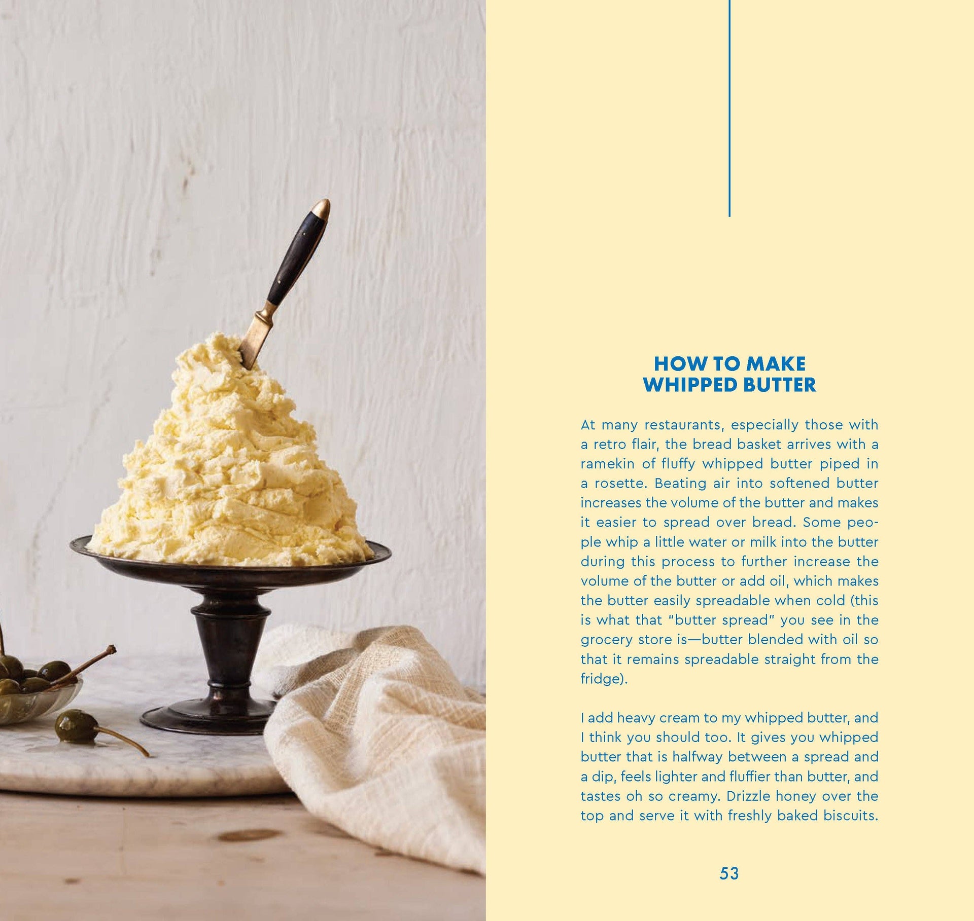 Whipped butter on a small black stand with a knife, on a light wooden surface.