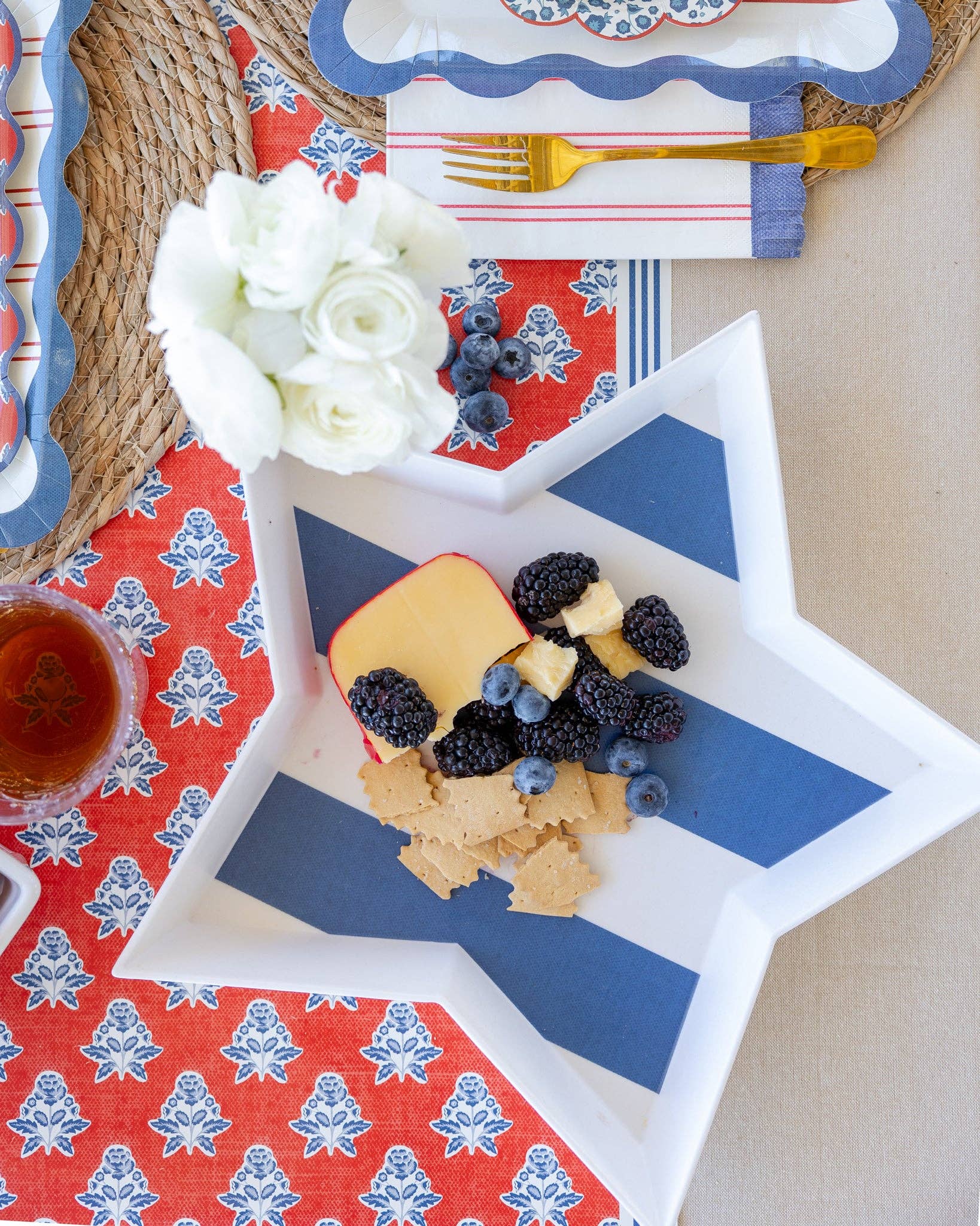 Star-shaped tray with fruit and cheese on a patterned tablecloth