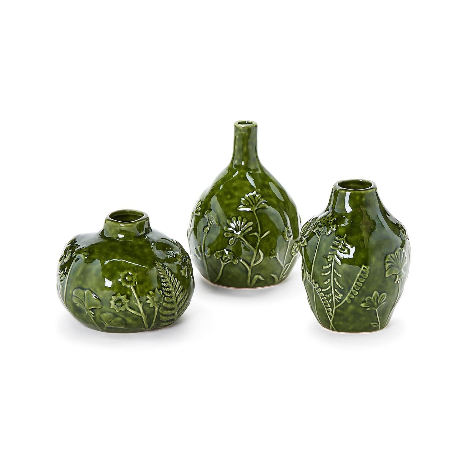 Three green ceramic vases with floral patterns on a white background