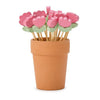 Terracotta pot with pink flower-shaped toothpicks on a white background