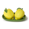 Two lemon-shaped salt and pepper shakers on a green tray with a white background