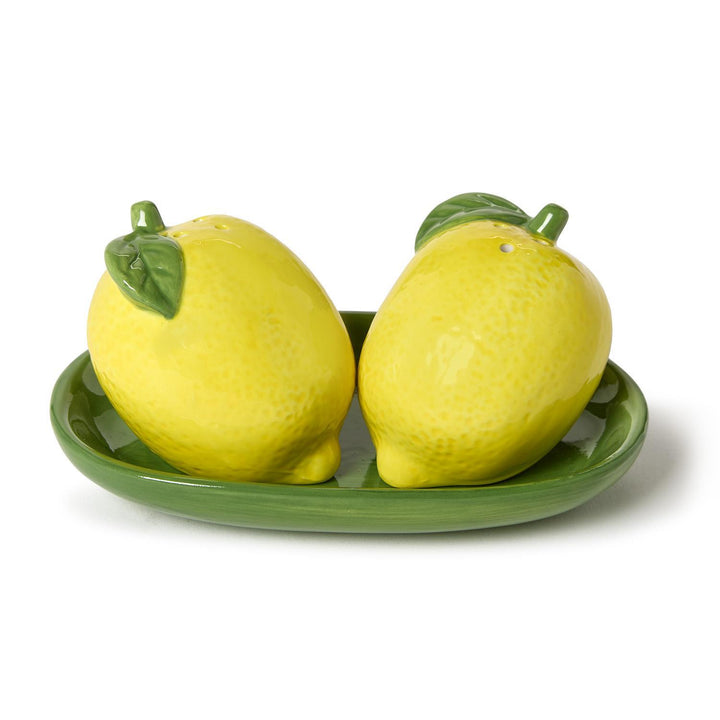 Two lemon-shaped salt and pepper shakers on a green tray with a white background