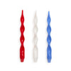 Three twisted candles in red, white, and blue on a white background