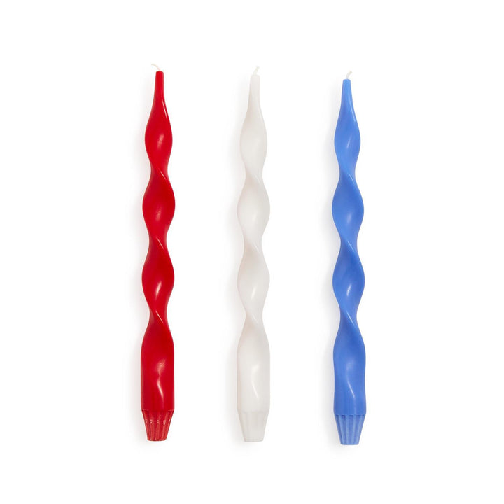 Three twisted candles in red, white, and blue on a white background