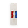 Packaged candles in red, white, and blue with a visible brand logo on a white background